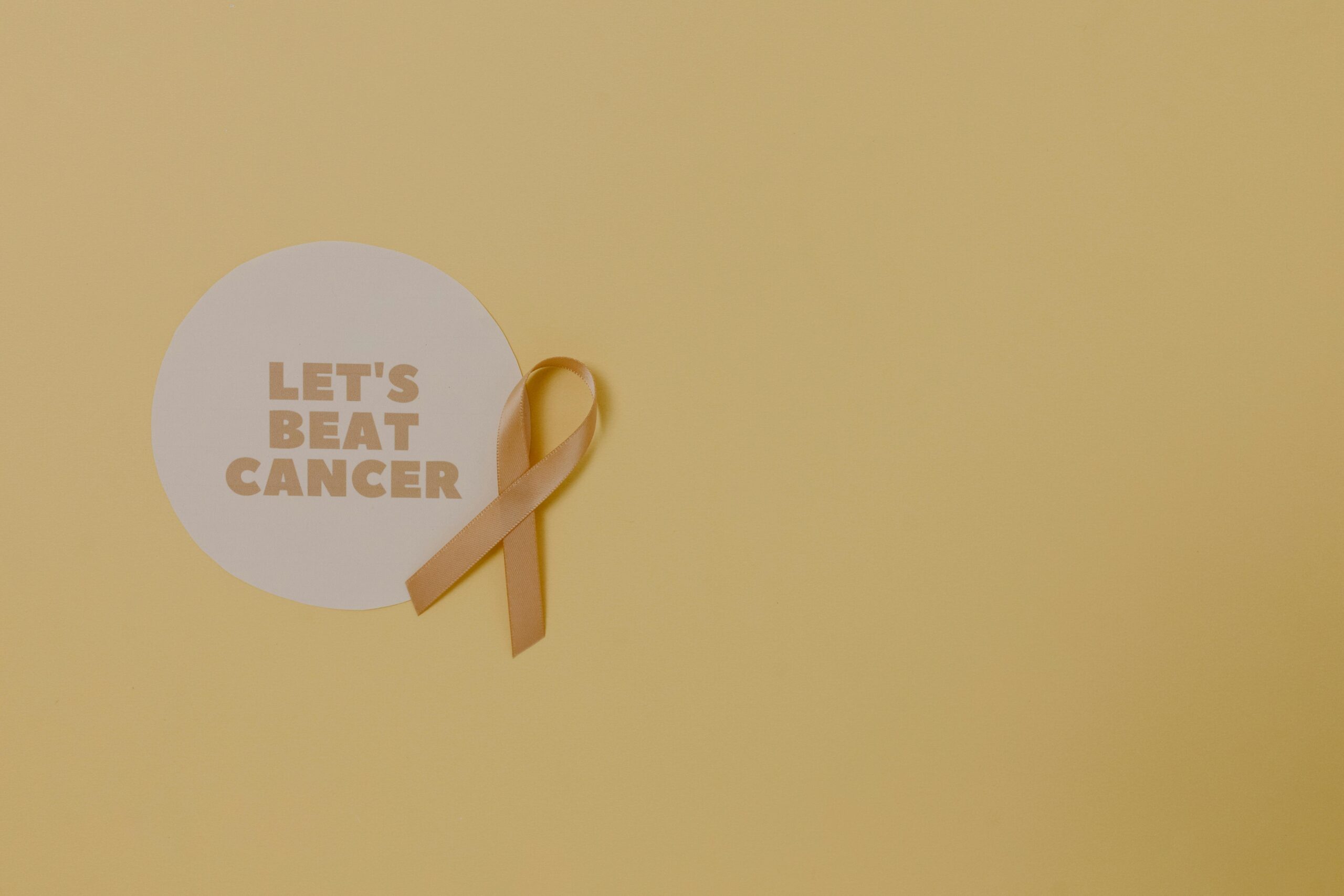 Minimalist design featuring a ribbon and 'Let's Beat Cancer' message for cancer awareness.